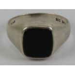 A Stirling silver and onyx signet ring, central square shaped stone, stamped 925 STG, size V.