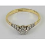 An 18ct gold and diamond ring, the central round cut brilliant cut diamond approx 0.