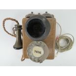 A vintage wall mounted telephone having twin brass hemispherical bells with mouth and ear pieces,