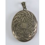 A large white metal locket having rope twist with ivy engraved pattern to front. 6.2cm in length.