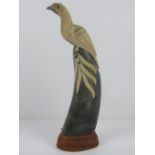 A horn carved into a figure of a bird and mounted upon wooden base, standing 29.