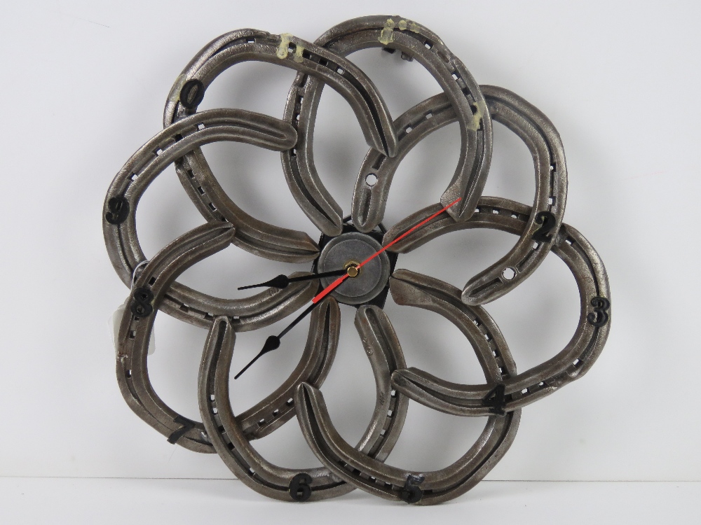 A wall clock formed from eight horseshoes and having central quartz movement, slightly a/f,