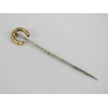A horse shoe stock pin or tie pin, yellow and white metal.
