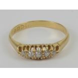 An 18ct gold diamond ring having carved head set with five graduated round cut stones,