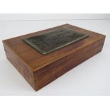A simple lidded mahogany box having cast copper relief plate depicting a view of Sakurajima