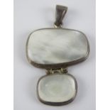 A hallmarked silver and mother of pearl pendant having articulated panels and measuring 4.