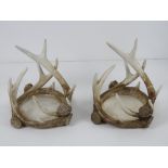 A pair of 'antler' wine bottle coasters, each approx 17cm wide, 15cm high.