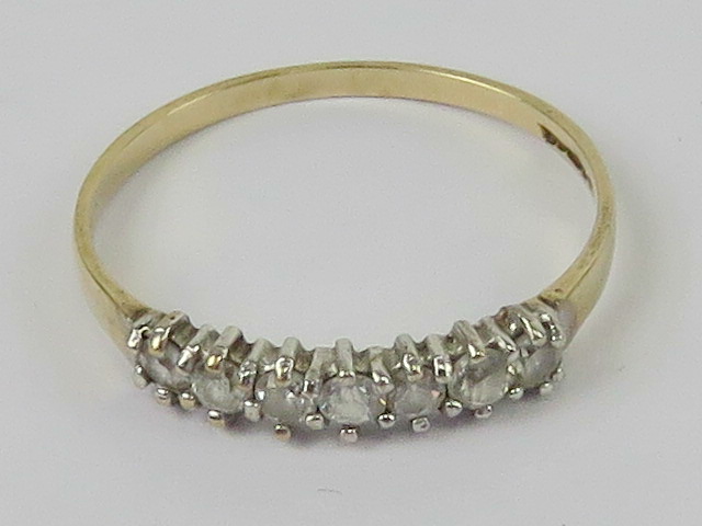 A 9ct gold ring set with seven cz stones, size P, 1.2g.