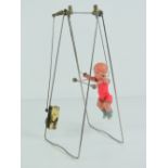 A Jitsuyo O Shinan Japanese clockwork trapeze acrobat, celluloid doll on a metal frame, c1930-50s,