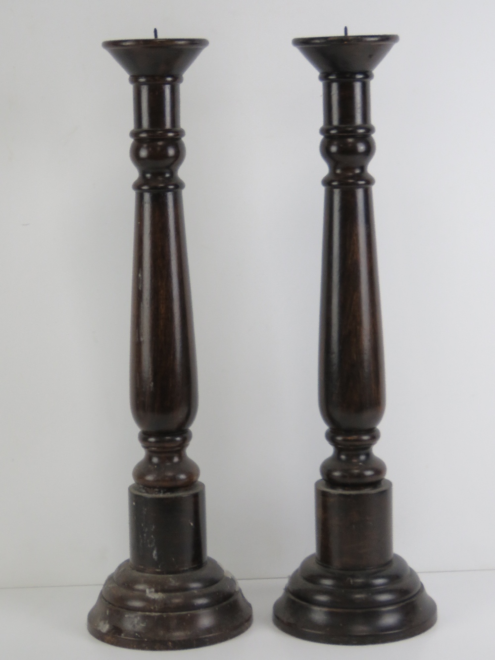 A pair of large turned wooden candlesticks, each 56.5cm high not inc spike.