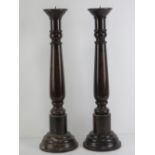 A pair of large turned wooden candlesticks, each 56.5cm high not inc spike.