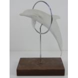 A ceramic model of a dolphin jumping through a hoop bearing Kaiser Exclusive label to wooden base,
