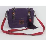 Guess; a purple and hot pink leather handbag with stud work to front and removable tassel,