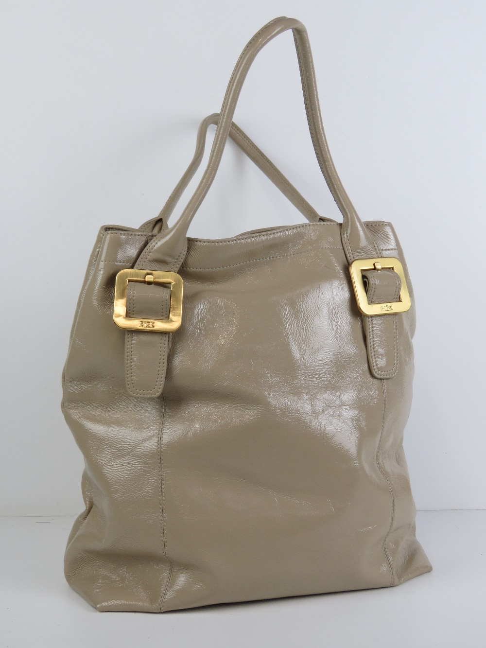 Ri2K; a beige patent ladies handbag, 100% leather outer, with dustbag, approx 17" high x 13" wide.