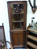 AN EARLY 20th.C.OAK FLOOR STANDING CORNER CABINET WITH CARVED DECORATION, SIX PANE GLAZED UPPER OVER