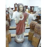 A COMPOSITION FIGURE OF JESUS CHRIST, HIS PIERCED HAND RAISED, A HEART ENTWINED WITH THORNS ON THE