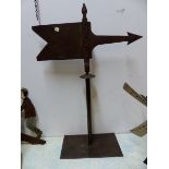 AN IRON WEATHER VANE IN THE FORM OF A PENNANT AND ARROW, NOW MOUNTED ON A RECTANGULAR BASE. H