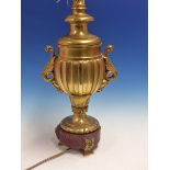 A FRENCH GILT BRONZE LAMP BASE OF BALUSTER SHAPE, THE FLUTED BODY WITH LEAF HANDLES AND THE RED