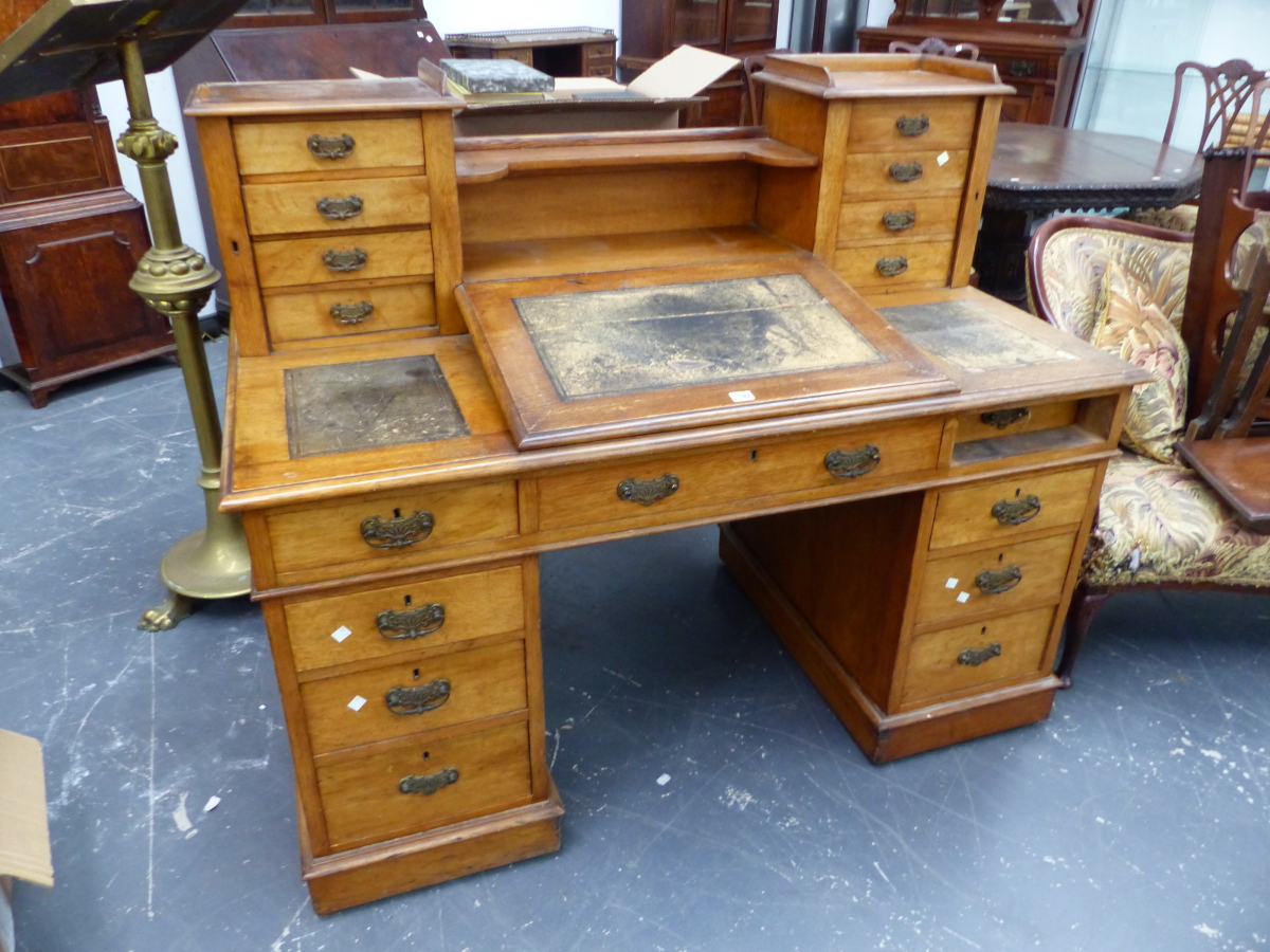 AN OAK PEDESTAL DICKENS DESK, THE LEATHER INSET FALL FLANKED BY FURTHER INSETS BEFORE