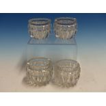 A SET OF FOUR ROUND CLEAR GLASS SALTS, THE SERRATED RIMS ABOVE ROUNDED SIDES WITH THE DEEP