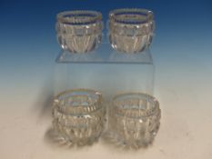 A SET OF FOUR ROUND CLEAR GLASS SALTS, THE SERRATED RIMS ABOVE ROUNDED SIDES WITH THE DEEP