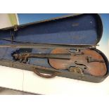 A WOODEN CASED VIOLIN AND BOW, THE BACK. H 35cms. THE OVERALL LENGTH. 59cms.