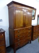 A LATE GEORGIAN MAHOGANY LINEN PRESS WITH PANEL DOORS ENCLOSING SLIDES OVER FOUR LONG GRADUATED