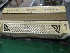 A LEATHERETTE CASED HOHNER SUPREMUS PIANO ACCORDIAN WITH SPANGLED WHITE PLASTIC MOUNTS