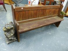 AN OAK PEW, THE TOP RAIL ABOVE THE PLANK BACK, THE END BOARDS FORMING THE FEET AND CARVED WITH