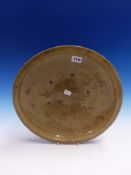 A CELADON DISH, THE SHALLOW CURVED CENTRE WITH SIX SPUR MARKS. Dia. 35.5cms