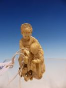 A JAPANESE IVORY OKIMONO OF TWO CHILDREN FEEDING A PUPPY. H.8cms.