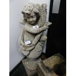 A VINTAGE WEATHERED GARDEN FIGURE OF PUTTI WITH WHEATSHEAF ATOP A SPHERE ON A PLINTH BASE. H.