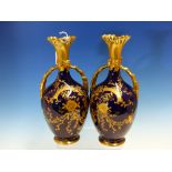 A PAIR OF REDON LIMOGES BLUE GROUND VASES WITH GILT HANDLES AND FOLIAGE DECORATION. H 24cms.