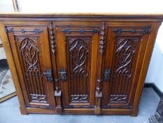 A 19th.C.GOTHIC CARVED OAK CABINET WITH IRONWORK LOCKS AND HINGES. W.128 x H.101cms.