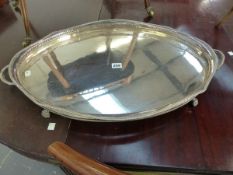 A SILVER ON COPPER TWO HANDLED GALLERIED OVAL TRAY ON FOUR PAW FEET. W 71cms.