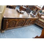 A LARGE ANTIQUE OAK COFFER THE CLEATED THREE PLANK LID OVER SIX ROUNDELS INLAID IN THE FRONT ARCH