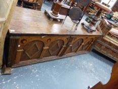 A LARGE ANTIQUE OAK COFFER THE CLEATED THREE PLANK LID OVER SIX ROUNDELS INLAID IN THE FRONT ARCH