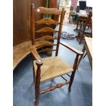 A COUNTRY ELM AND ASH LADDER BACK ARMCHAIR WITH ROUNDED FINIALS.