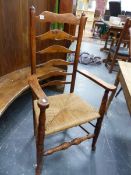 A COUNTRY ELM AND ASH LADDER BACK ARMCHAIR WITH ROUNDED FINIALS.