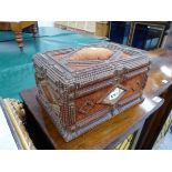 A TRAMP ART CASKET, THE CHIP CARVED WOOD WORK EDGING BROWN VELVET, THE FRONT AND BACK WITH CENTRAL