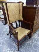 AN ARTS AND CRAFTS MAHOGANY HIGH BACK WING ARMCHAIR WITH SPINDLE SUPPORTS ON SQUARE LEGS.