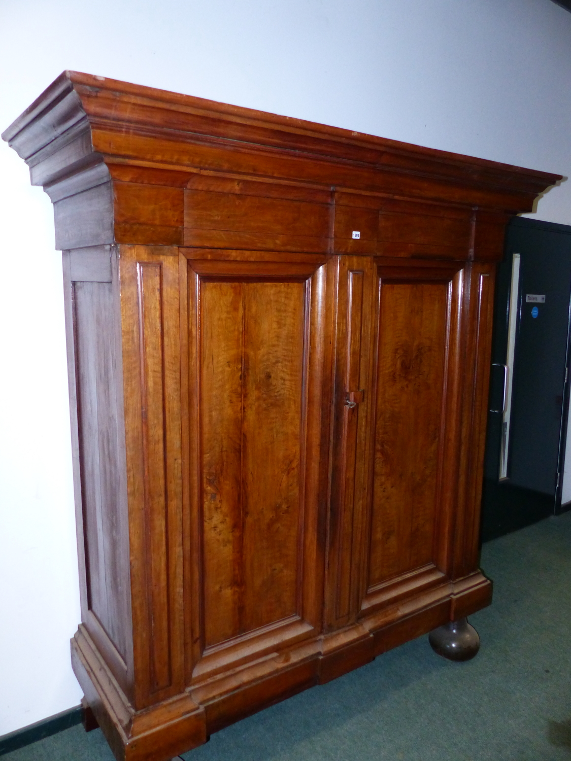 AN EARLY CONTINENTAL WALNUT BAROQUE STYLE ARMOIRE OF HEAVY CONSTRUCTION WITH MOULDED CORNICE, TWIN