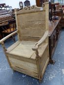 AN 18TH CENTURY OAK LAMBING CHAIR, A SCROLL TOP RAIL TO A PANELLED BACK OVER THE BOX SEAT ON BUM