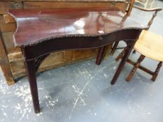 A GEORGIAN MAHOGANY TABLE, THE SERPENTINE FRONT EDGE CARVED WITH RIBBON AND FLOWER HEADS ABOVE A