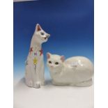 A BRANNAM WHITE SEATED CAT COLOURED WITH STARS, H.34cms TOGETHER WITH A WHITE POTTERY CAT