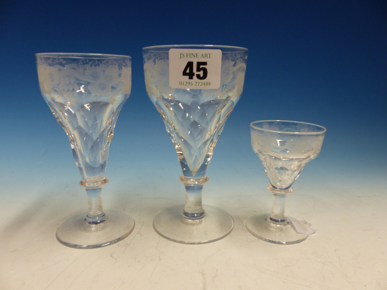 A CLEAR GLASS PART DRINKING SUITE, EACH CONICAL BOWL ENGRAVED WITH GRAPES ABOVE FACETTING, DISC