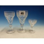 A CLEAR GLASS PART DRINKING SUITE, EACH CONICAL BOWL ENGRAVED WITH GRAPES ABOVE FACETTING, DISC