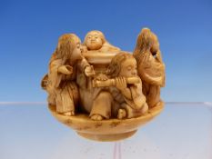 TOMOMASA, AN IVORY OKIMONO OF SIX CHILDREN PLAYING MUSIC AND DANCINGING WITHIN A SAUCER, SIGNED.