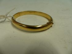 A 9ct GOLD HINGED BANGLE WITH A CHESTER HALLMARK.