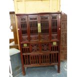 A CHINESE HARDWOOD FOOD CUPBOARD, THE PIERCED SCROLLING FOLIAGE PANELS AT THE TOP OVER SLATTED DOORS